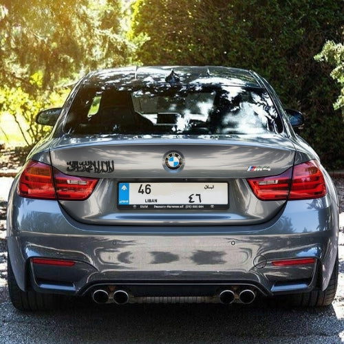 Back view of a silver BMW car with shahada emblem on the rear